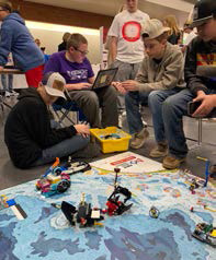 Robotics team looking over competition on the floor